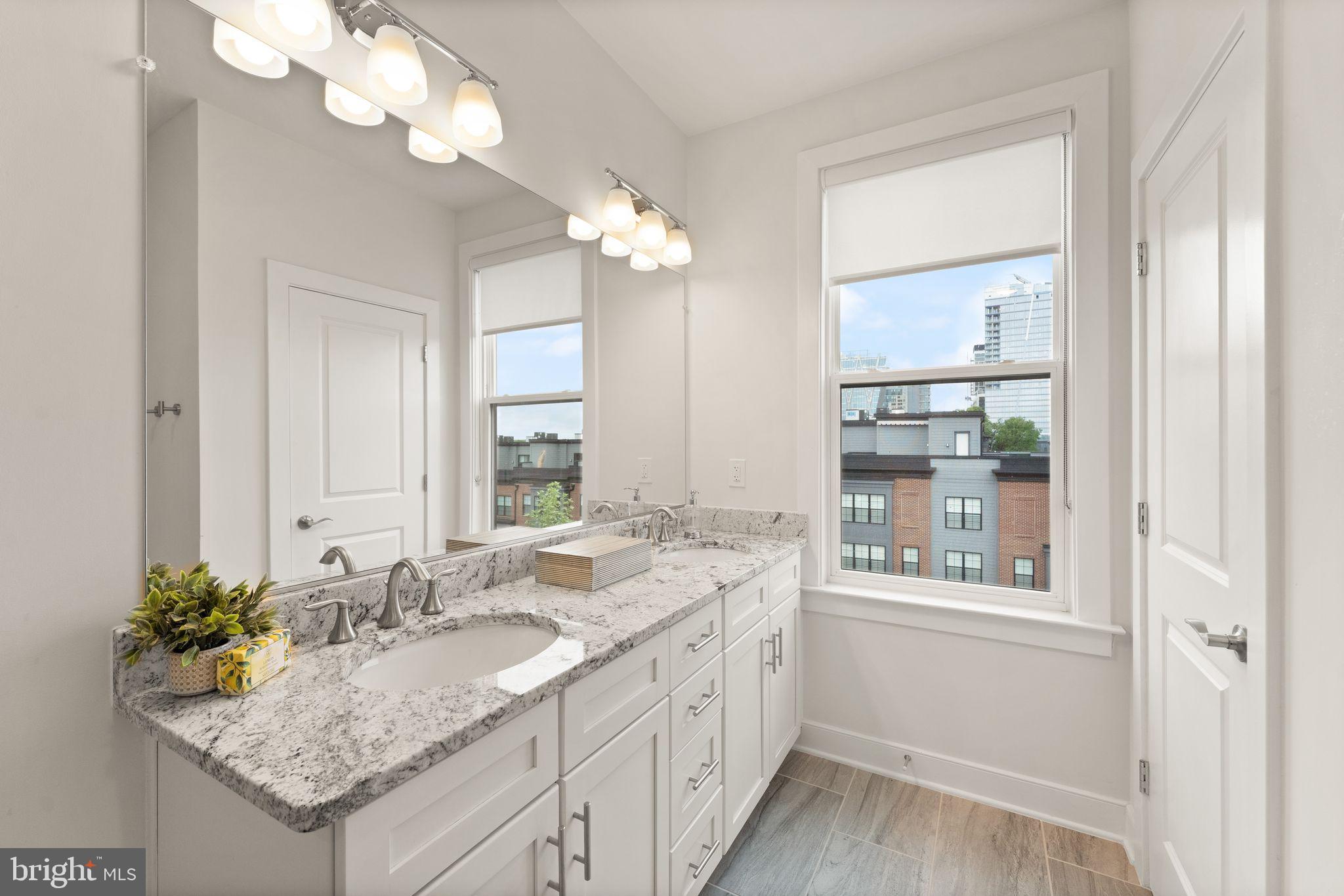 1867 Michael Faraday Drive, Unit 4 Reston, VA 20190 - Photo 33 of 53 a bathroom with a granite countertop sink and a mirror