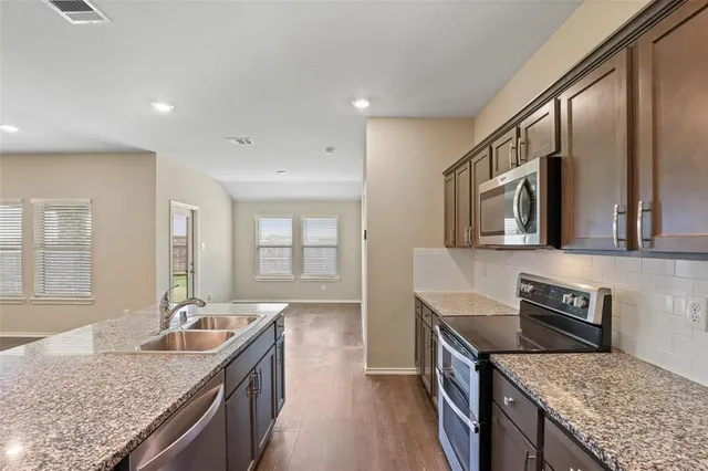 a kitchen with granite countertop counter top space a sink stainless steel appliances and cabinets