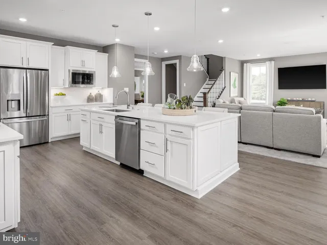 a kitchen with a sink stainless steel appliances a refrigerator and a cabinets