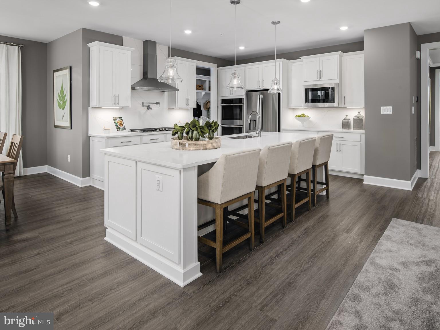1221 Bear Branch Road Laurel, MD 20708 - Photo 3 of 22 a kitchen with stainless steel appliances kitchen island wooden floors and white cabinets