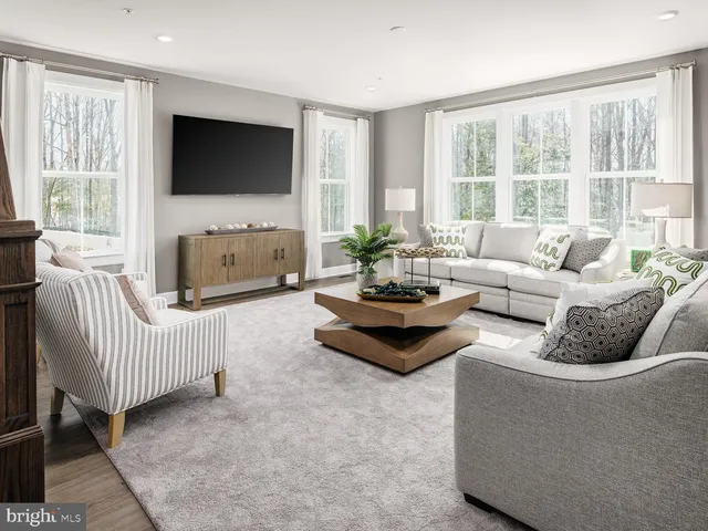 a living room with furniture a flat screen tv and a large window