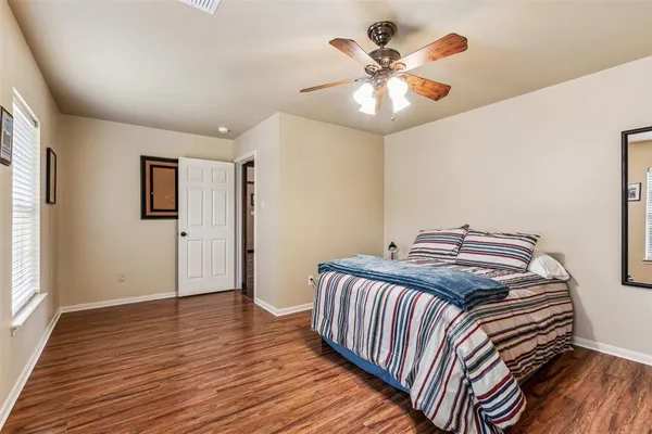 a bedroom with a bed and wooden floor