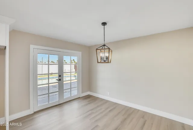 a open kitchen with a stove a sink dishwasher a refrigerator and white cabinets with wooden floor