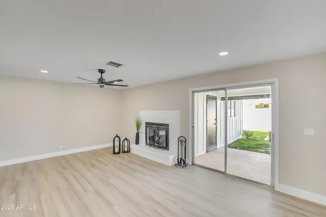 a view of empty room with wooden floor fireplace and window