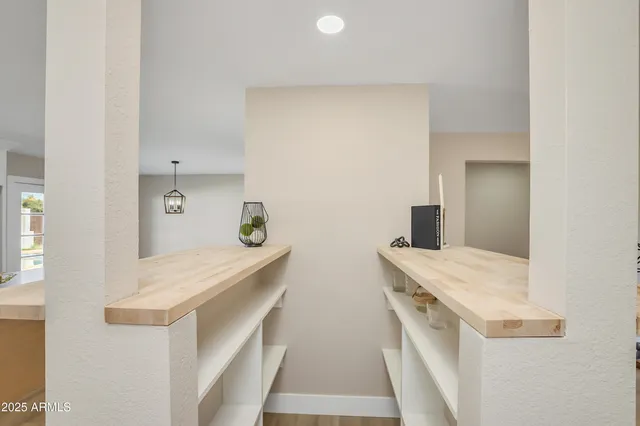a large white kitchen with a sink and dishwasher with wooden floor