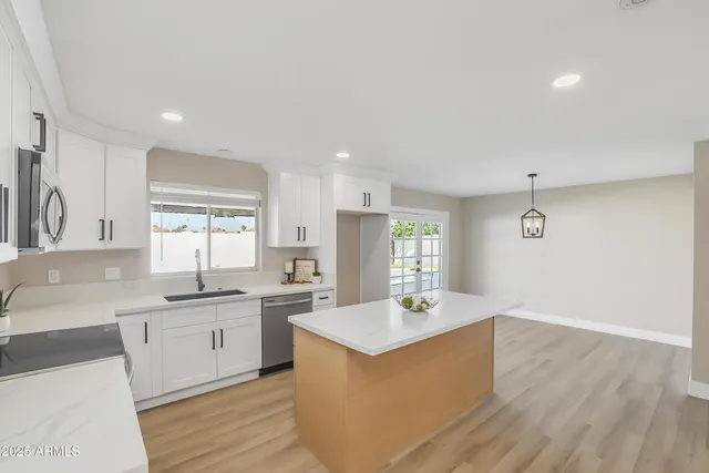 a kitchen with a wooden floor and white cabinets