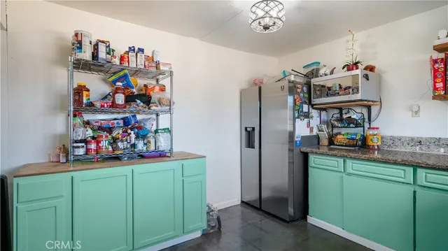 a view of a kitchen with fridge and workspace