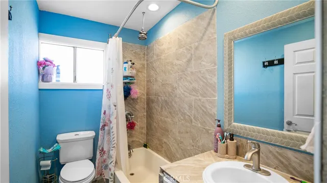 a white toilet sitting next to a bath tub