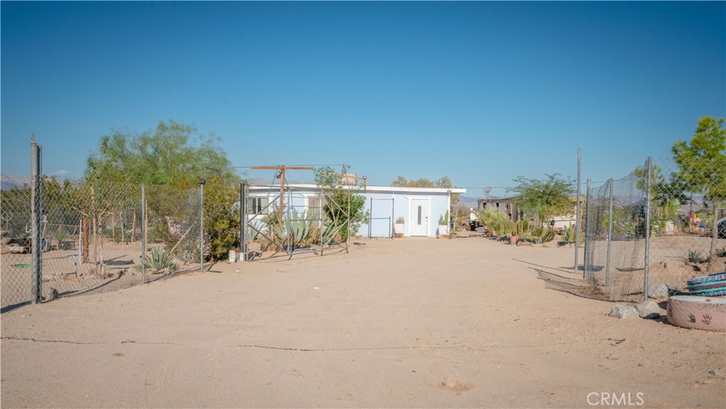 5737 Gammel Road Twentynine Palms, CA 92277 - Photo 2 of 48 a row of palm trees and a yard with wooden fence