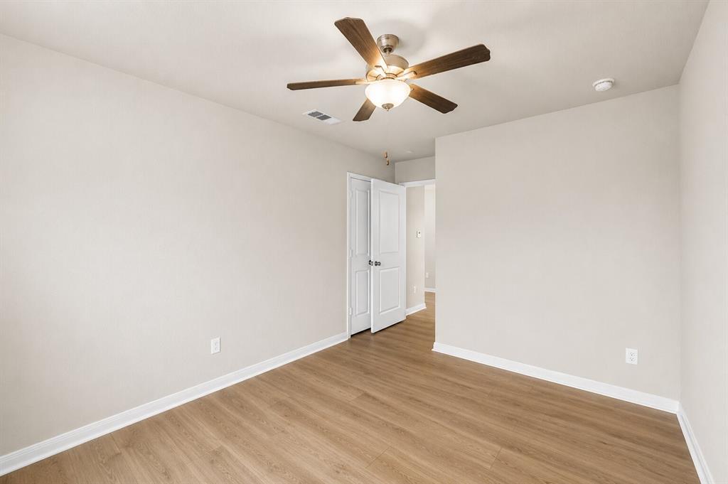 3213 Dottavio Road Lorena, TX 76655 - Photo 17 of 32 an empty room with wooden floor and a ceiling fan