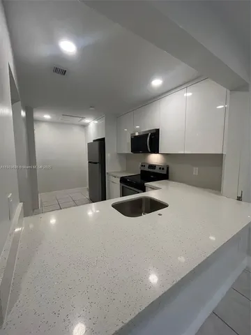 a kitchen with a refrigerator and a sink