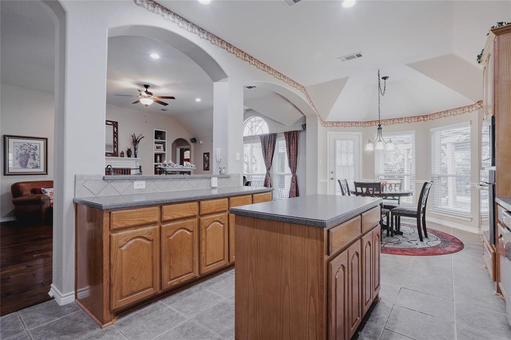 2314 Ranch Road Sachse, TX 75048 - Photo 13 of 27 Kitchen featuring wood cabinetry, stone-finish countertops, and a tile backsplash
