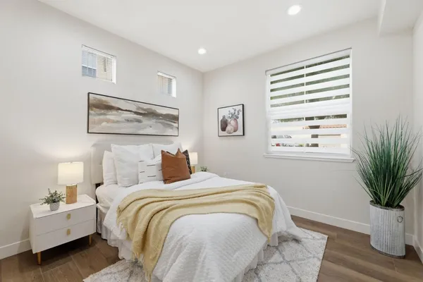 a bedroom with a bed and a potted plant