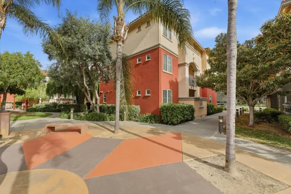 a view of a house with a yard and palm trees