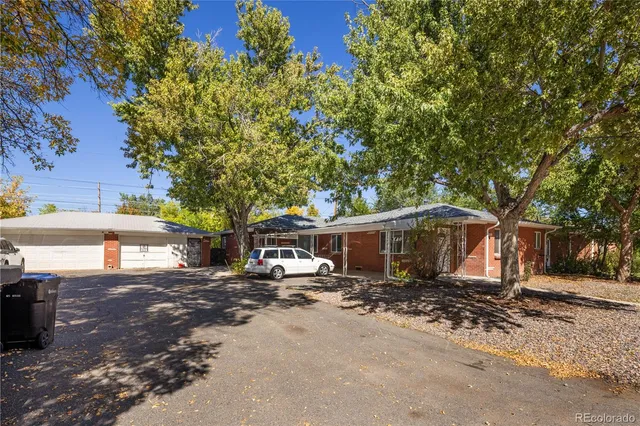 a view of a front of a house with large trees