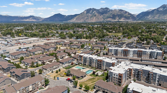 8248 South Resaca Drive, Unit J10 Sandy, UT 84070 - Photo 38 of 40 Expansive aerial view showcasing a residential community with multi-story apartment buildings and townhomes