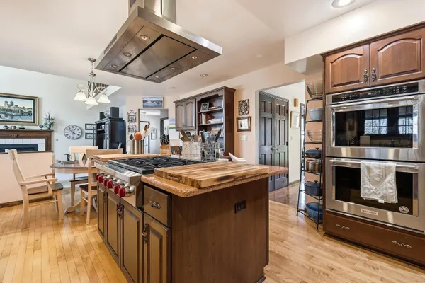 a kitchen with stainless steel appliances granite countertop a stove and a wooden floors