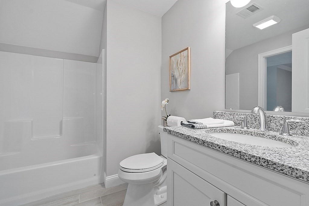 30 Wheeler Hill Road, Unit 61 Berlin, MA 01503 - Photo 22 of 31 a bathroom with a granite countertop sink a toilet and shower