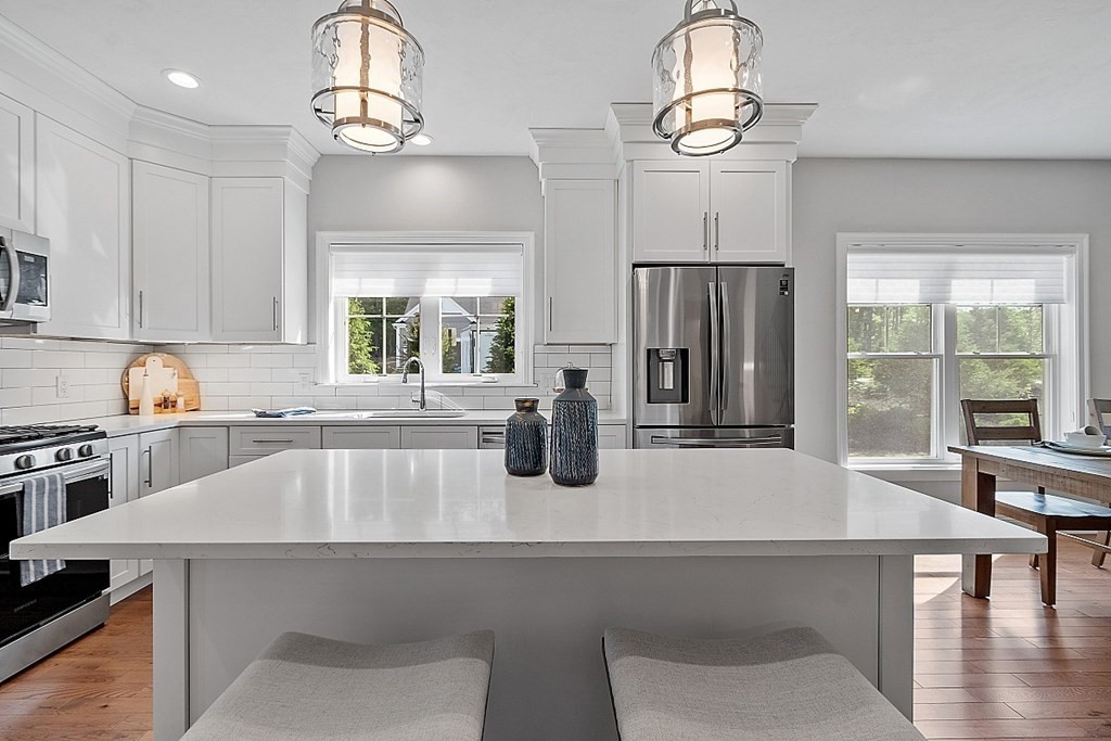 30 Wheeler Hill Road, Unit 61 Berlin, MA 01503 - Photo 6 of 31 a kitchen with a table chairs refrigerator and cabinets