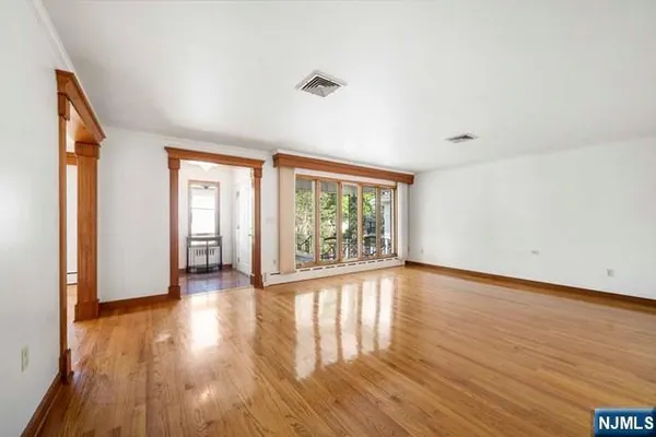 a view of empty room with wooden floor and ceiling fan