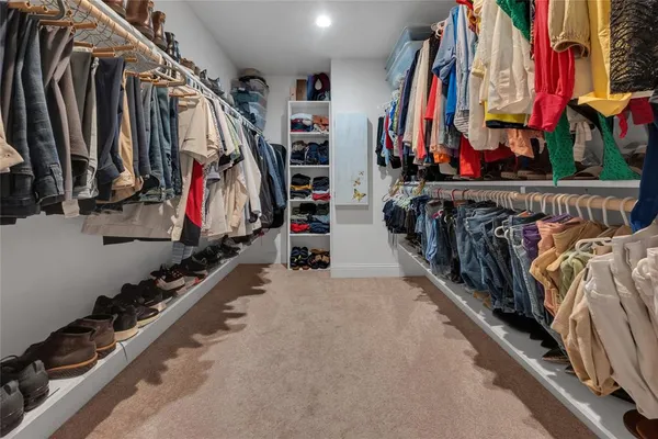 a view of walk in closet with clothes