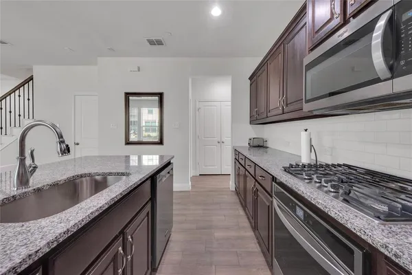 a kitchen with granite countertop a sink and stove top oven