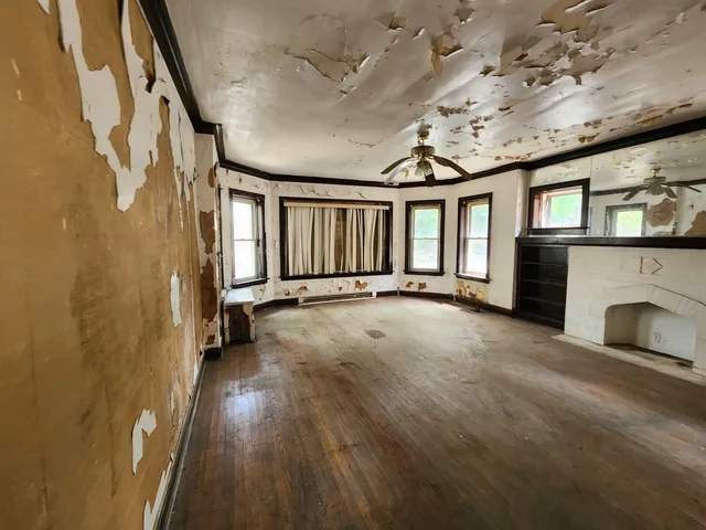 a view of an empty room with a fireplace and a window