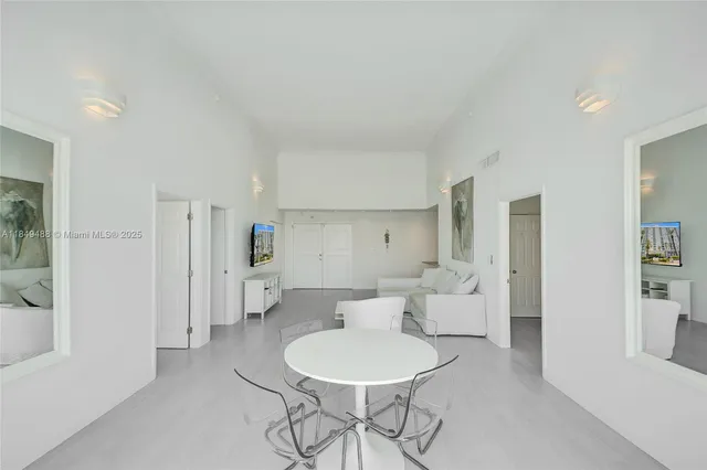 a living room with furniture and a refrigerator