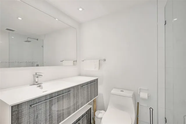 a white toilet sitting next to a bathroom sink