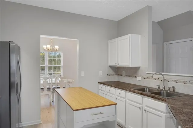 a kitchen with granite countertop a sink stove and refrigerator