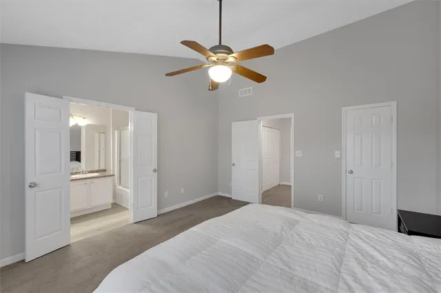 a bedroom with a bed and a chandelier fan