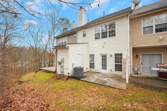 a backyard of a house with large trees and barbeque oven