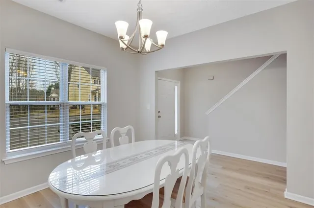 a view of a dining room with furniture wooden floor and chandelier