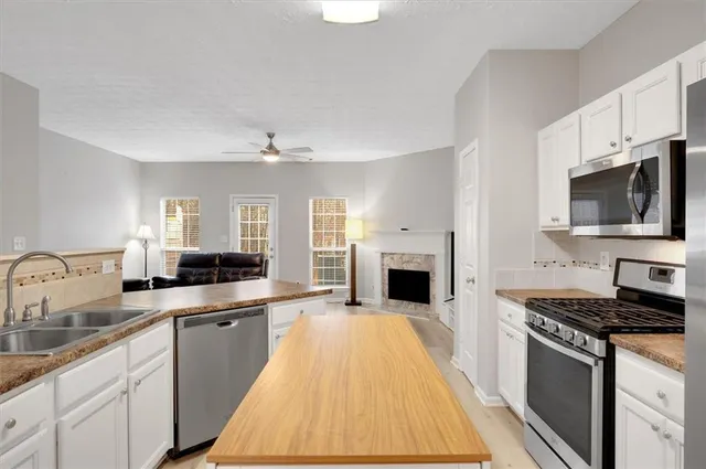 a large kitchen with cabinets counter top space stainless steel appliances and a window
