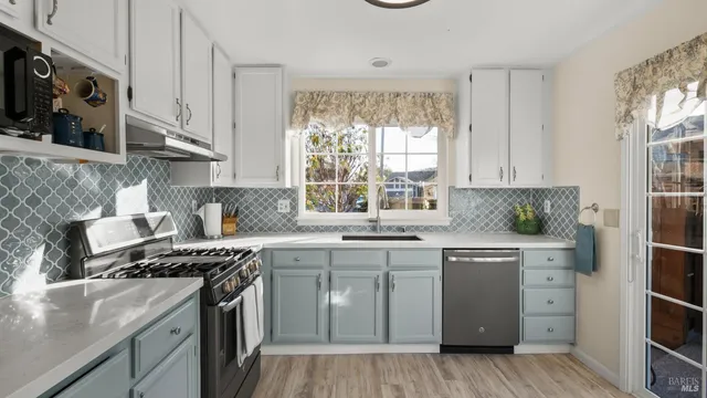 a kitchen with a sink stove and cabinets