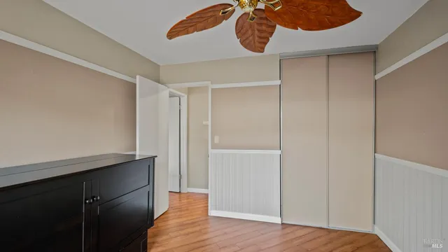 a bedroom with a bed a dresser and a large window