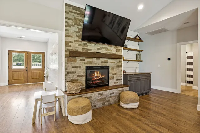 a kitchen with stainless steel appliances granite countertop a stove top oven a sink dishwasher and a dining table with wooden floor