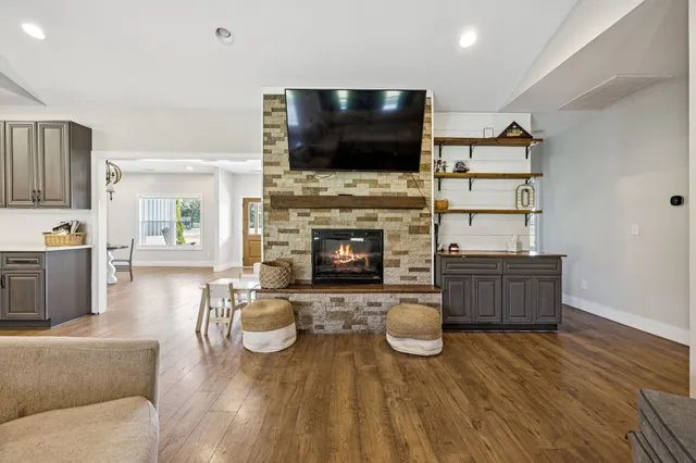 a kitchen with stainless steel appliances kitchen island granite countertop a lot of counter space and wooden floors