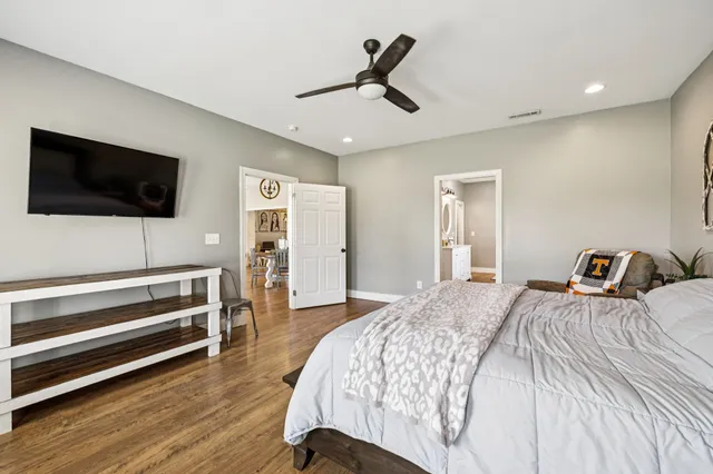 a bedroom with a bed a flat screen tv and dresser