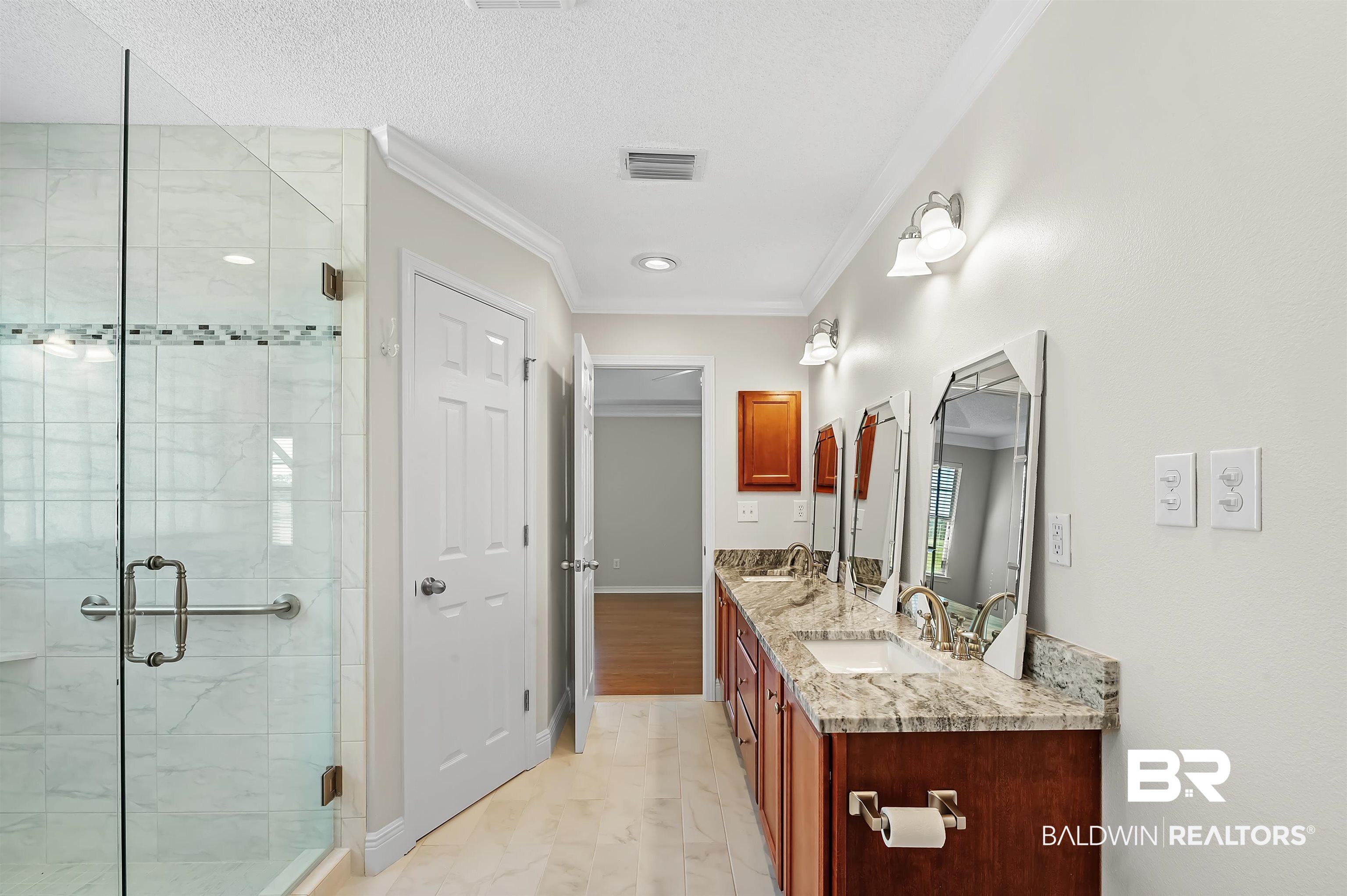 421 Collinwood Loop Foley, AL 36535 - Photo 39 of 62 Bathroom with hardwood / wood-style floors, a textured ceiling, walk in shower, ornamental molding, and vanity