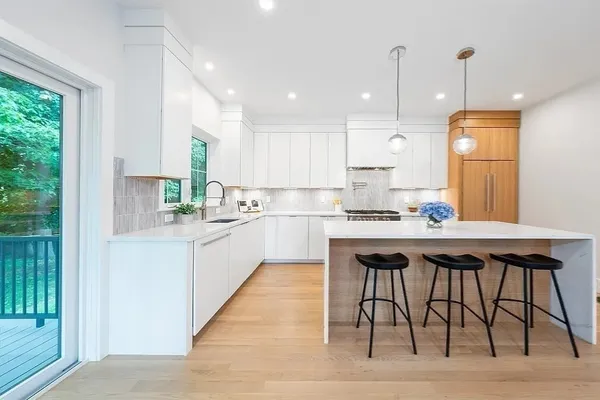 a kitchen with stainless steel appliances granite countertop a stove a sink dishwasher and a refrigerator with wooden floor