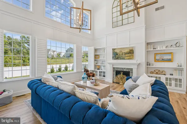 a living room with fireplace furniture and a large window