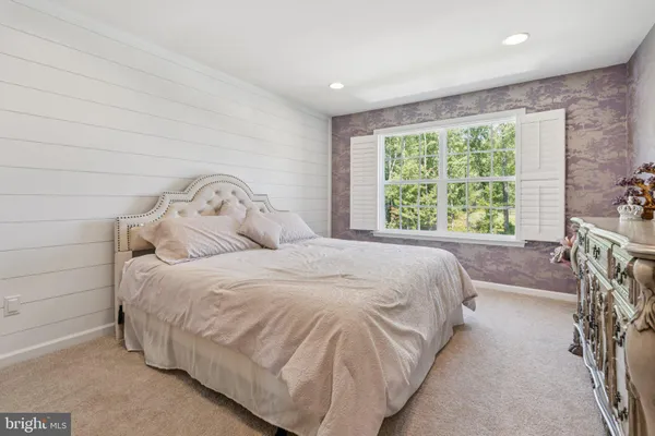 a large bed sitting in a bedroom next to a window