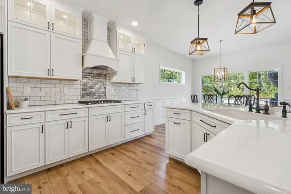 a kitchen with white cabinets and chandelier