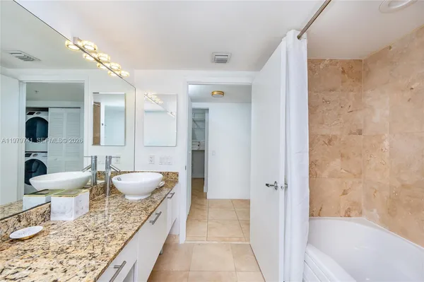 a large spacious bathroom with a granite countertop tub shower and sink