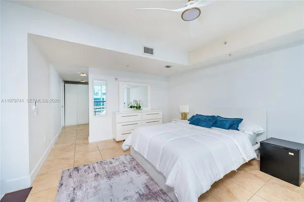 a spacious bedroom with a bed and a view of bathroom