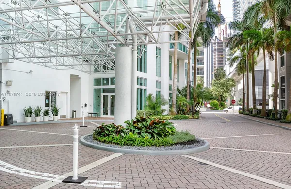 a view of a building with a yard and potted plants