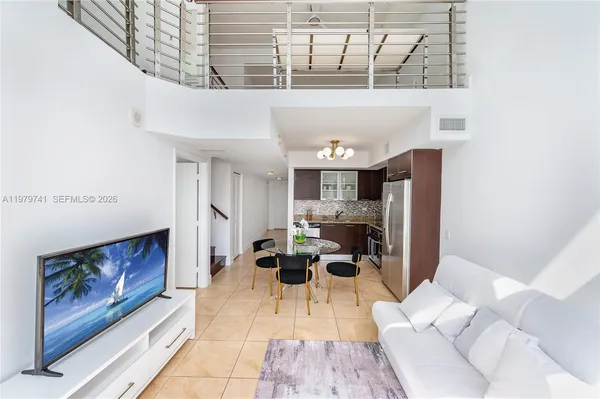 a living room with furniture a rug and white walls