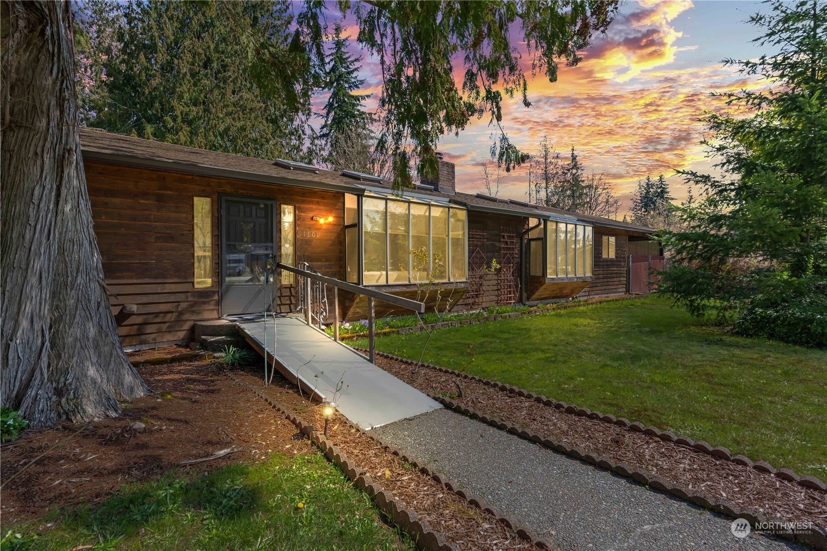 a view of a house with backyard and sitting area