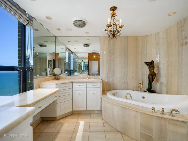 a bathroom with a tub sink and mirror